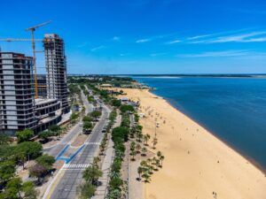 Stunning aerial photo captures Corrientes beachfront, showing urban skyline and sandy shoreline.