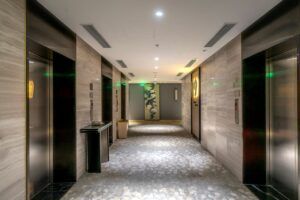 pexels-photo-26729563-26729563 Spacious hotel hallway with elevators and contemporary decor.