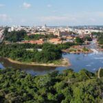 Stunning aerial view showcasing river, lush greenery, and a bustling cityscape.