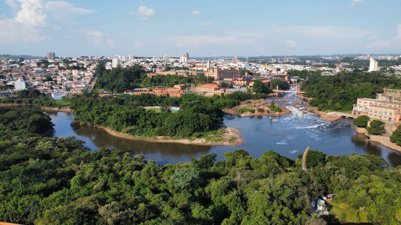 Stunning aerial view showcasing river, lush greenery, and a bustling cityscape.