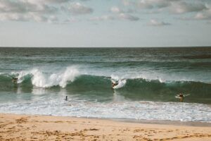 pexels-photo-4603230-4603230 Surfers ride the waves on a sunny day at the beach. Perfect for vacation vibes.