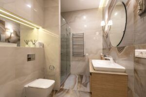 pexels-photo-8082195-8082195 Elegant bathroom with marble tiles, large mirror, and modern fixtures.
