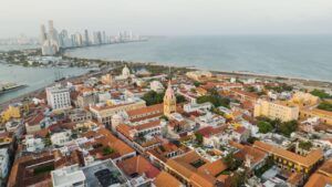 Drone view of Cartagena's historic center with modern skyline and ocean backdrop in Colombia.